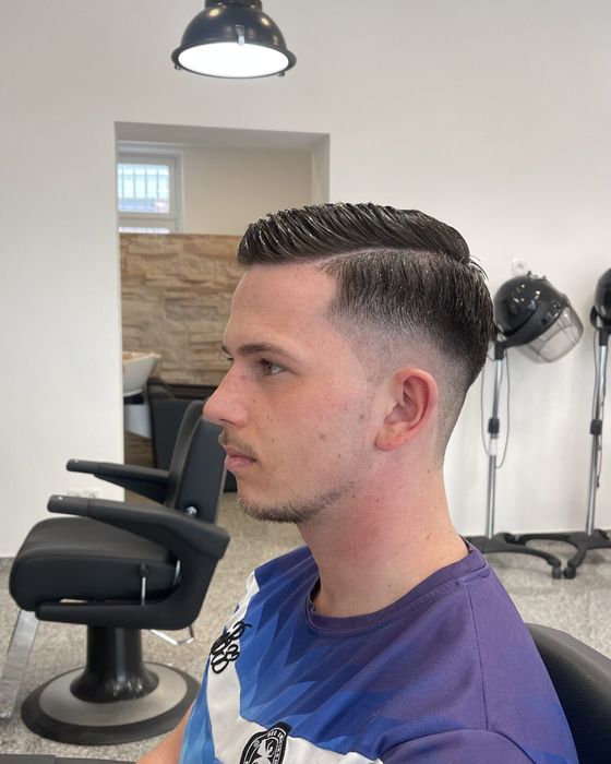 Herrenschnitt mit sauberem Übergang an den Seiten und gestyltem Deckhaar, seitliche Ansicht